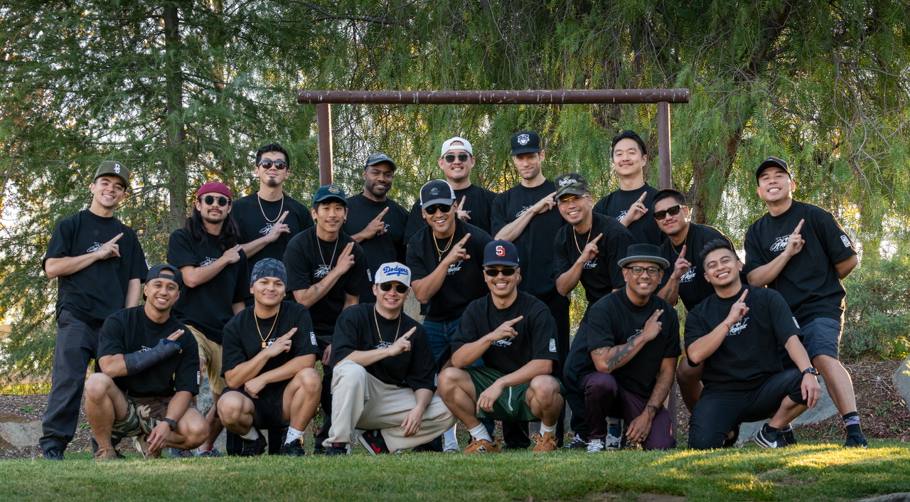 Members of Kinjaz pose with their signature hand sign during a group photo at their 15-year anniversary retreat.  (Courtesy of Kinjaz)