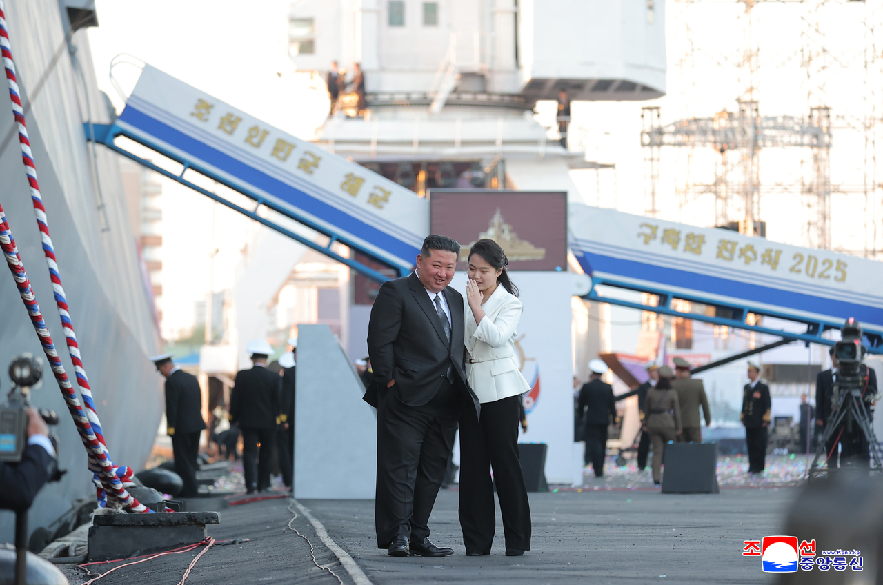 North Korean leader Kim Jong-un (left) and his daughter, known as Ju-ae, attend a launching ceremony of the country's new destroyer for the navy held at a shipyard in the North's western port city of Nampo on April 25 in this photo released by North Korea's state-run Korean Central News Agency the next day. (Yonhap)