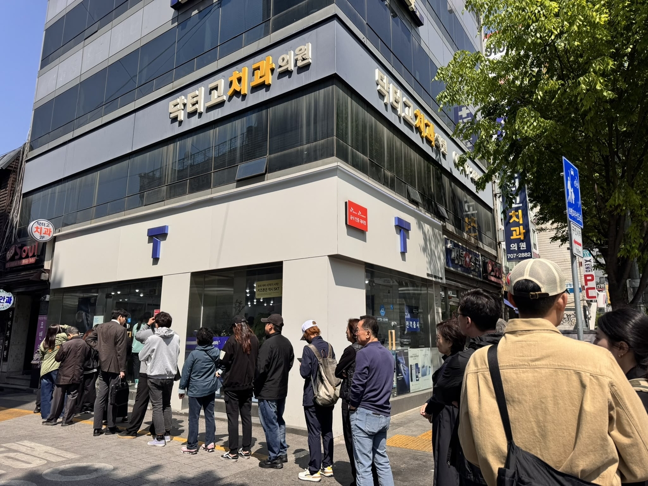 Customers wait outside SK Telecom’s branch in Yongsan-gu, Seoul, on Monday, as most seek to reserve appointments for new USIM cards following a major security breach. (Moon Joon-hyun/The Korea Herald)