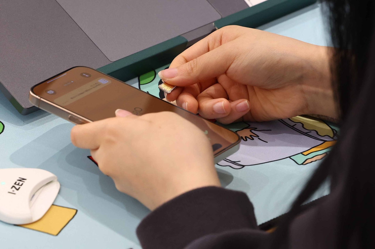 A worker replaces a USIM card at an SK Telecom's offline store in Seoul on Monday. (Yonhap)