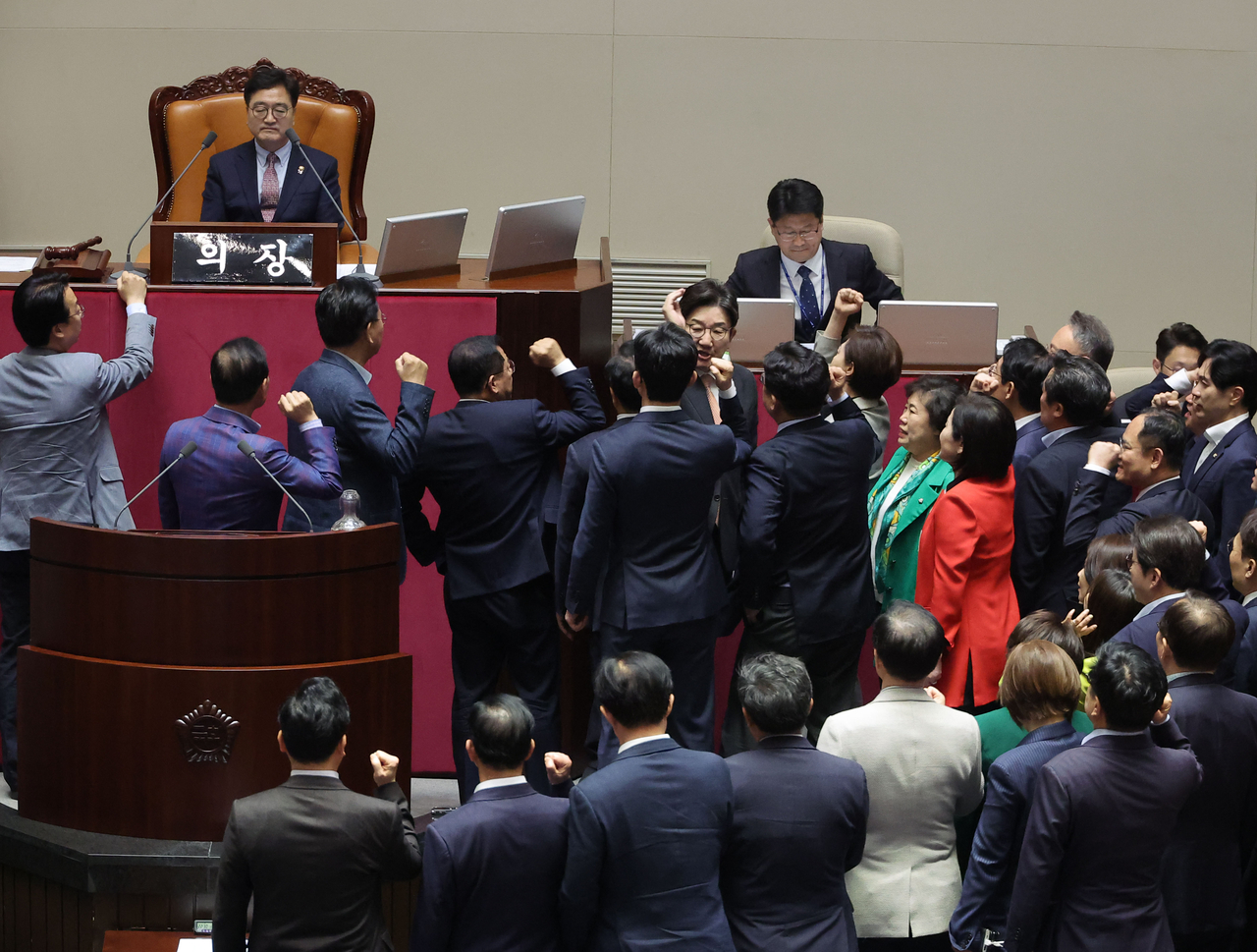 People Power Party lawmakers protest en masse over the decision by National Assembly Speaker Rep. Woo Won-shik (left, top) to put a motion to impeach Deputy Prime Minister Choi Sang-mok to a vote at the National Assembly's plenary session on Thursday. (Yonhap)