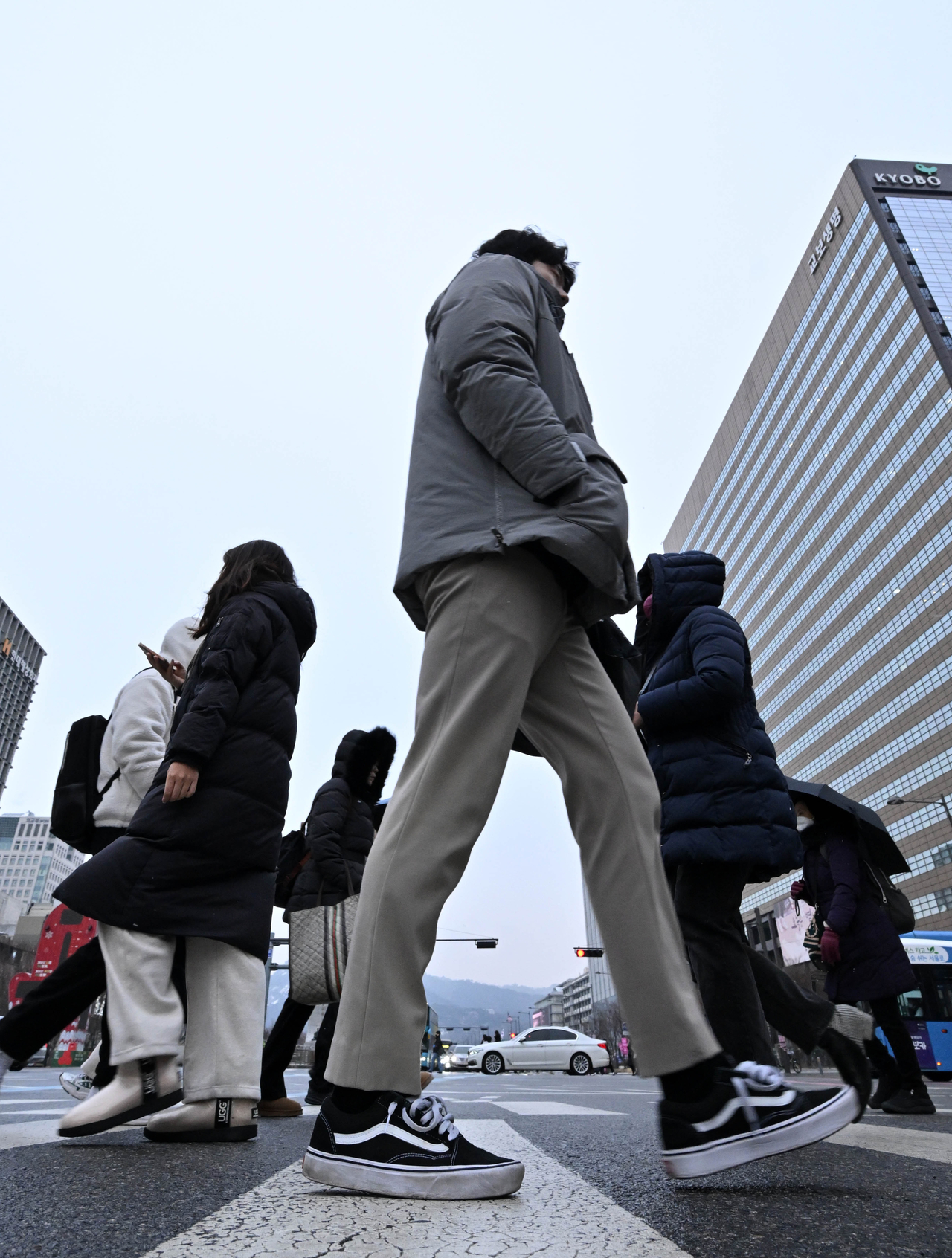 Pedestrians cross a street in Seoul’s Gwanghwamun business district on Jan. 31, the first working day following the Seollal holiday. (Im Se-jun/The Korea Herald)