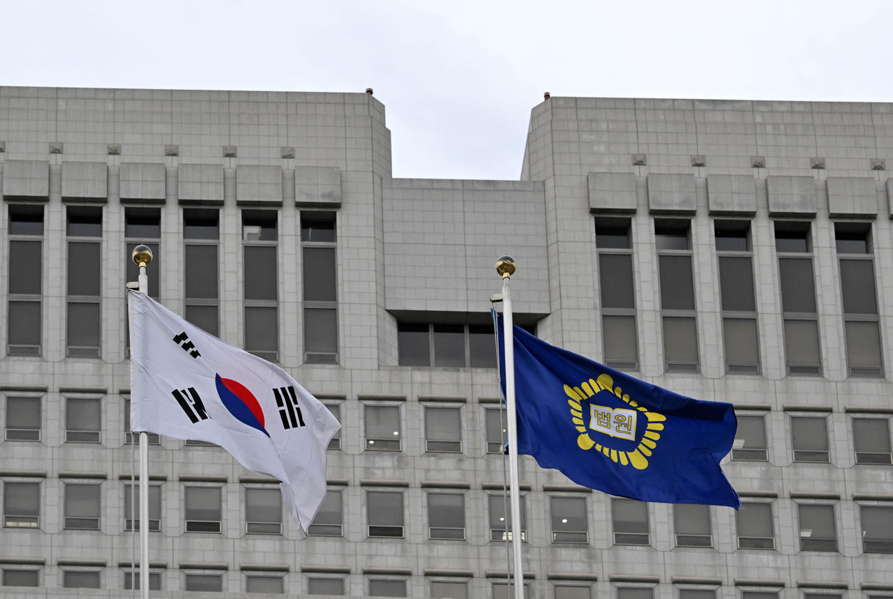 The national flag and the Supreme Court’s flag flutter in the wind outside the Supreme Court in Seocho-gu, Seoul, on Wednesday. (Im Se-jun/The Korea Herald)