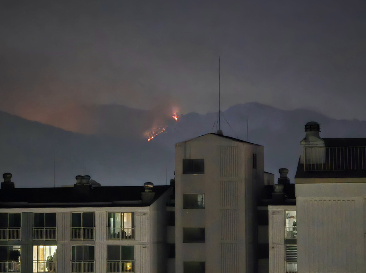 A wildfire on Hamjisan in Daegu reignites, as seen from an apartment complex in the city on Wednesday. (Yonhap)