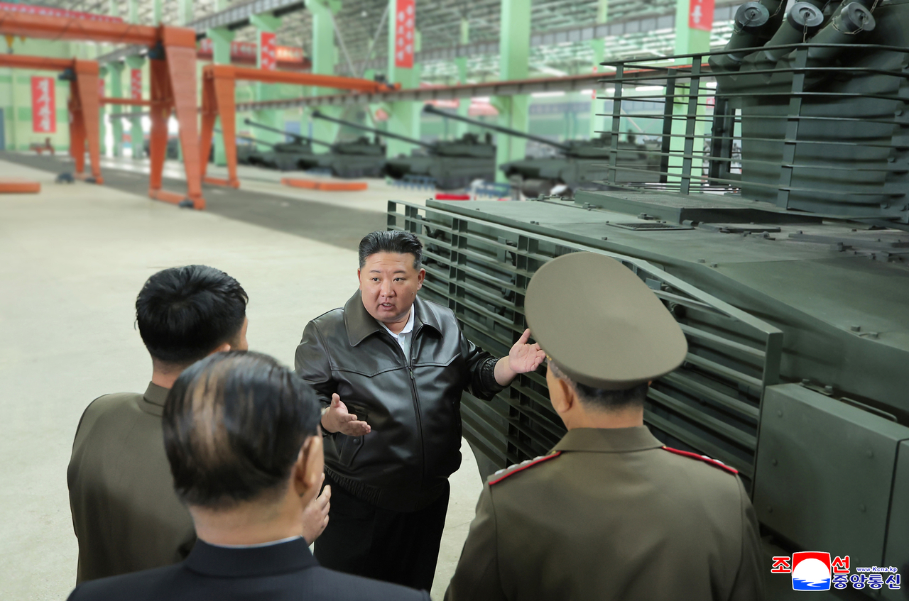 North Korean leader Kim Jong-un speaks with officials while inspecting a tank factory. The whereabouts of the factory or the timeframe of the visit were not stated. (Korean Central News Agency-Yonhap)
