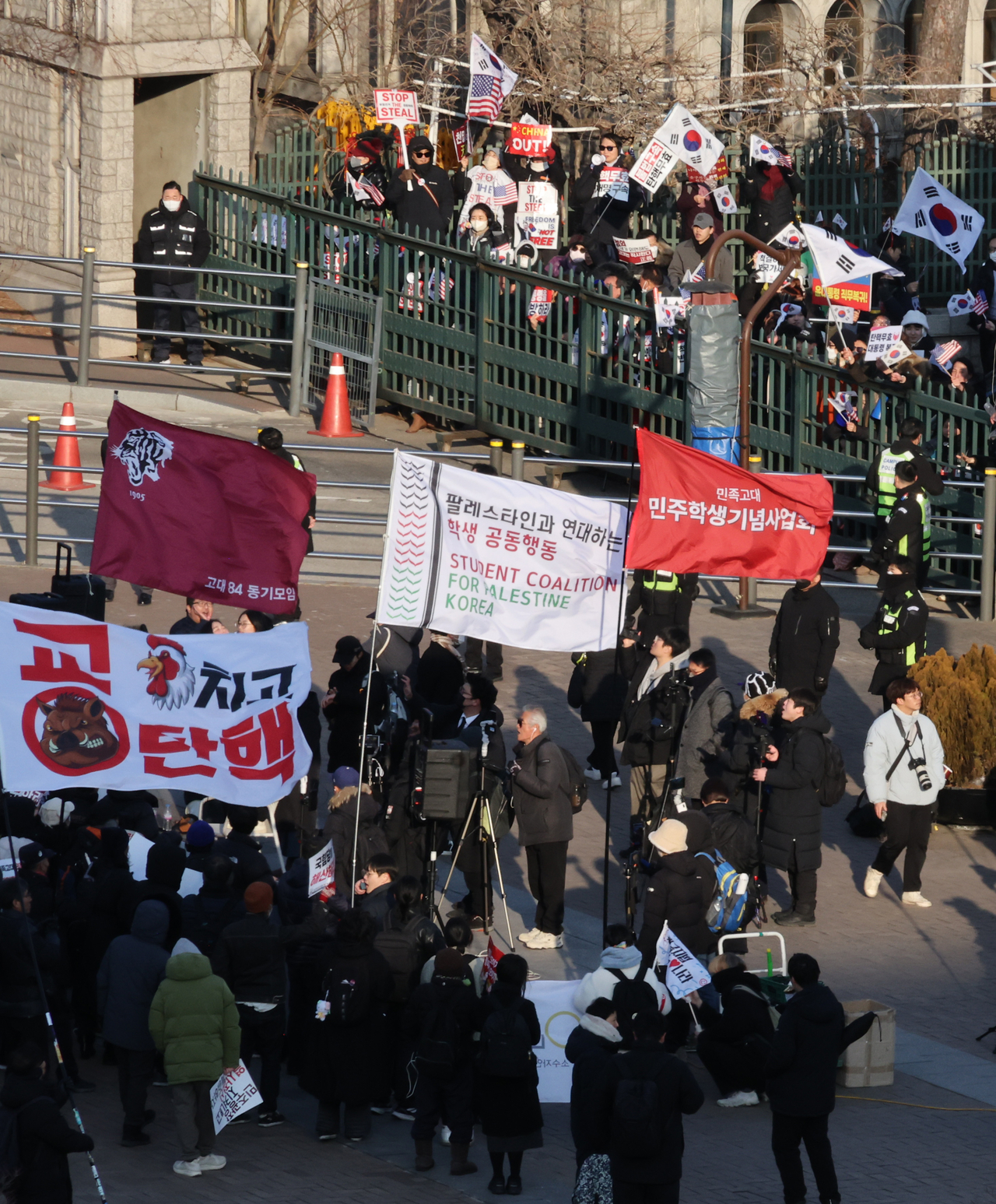 Protestors supporting the impeachment of President Yoon Suk Yeol hold a rally inside the main gate of Korea University's campus in Seongbuk-gu, Seoul, as those supporting Yoon hold an anti-impeachment rally outside the gate. (Yonhap)