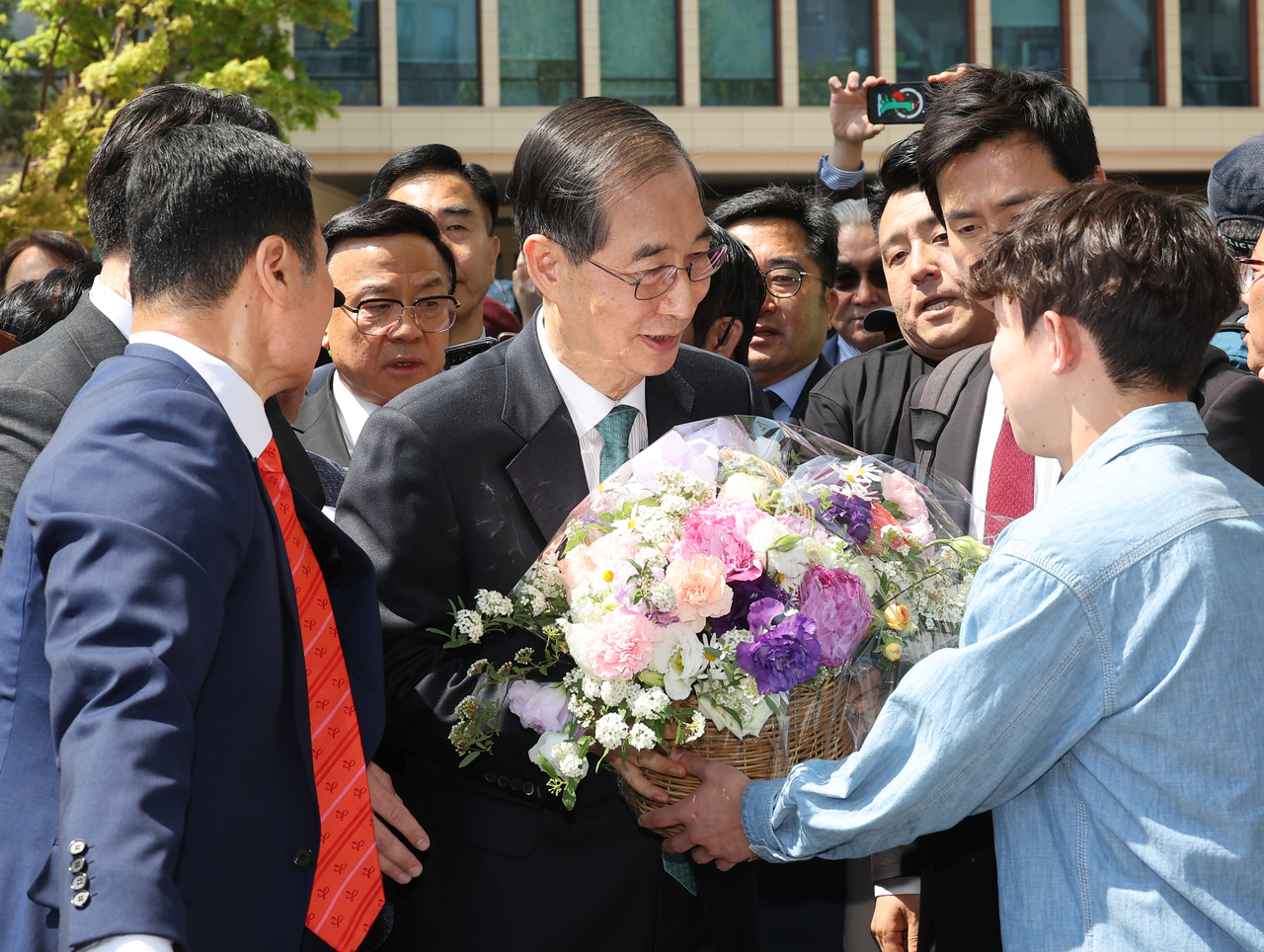 Former Prime Minister Han Duck-soo (center) receives flowers from a supporter after announcing his presidential bid at the National Assembly in Yeouido, Seoul, Friday. (Yonhap)